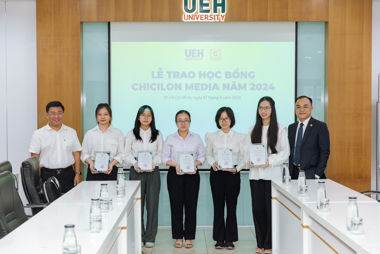 Mr. Tran Kim Long Hai - Chief Financial Officer of Chicilon Media (right) with Prof. Dr. Nguyen Khac Quoc Bao - Deputy Director of UEH awarding scholarships to students